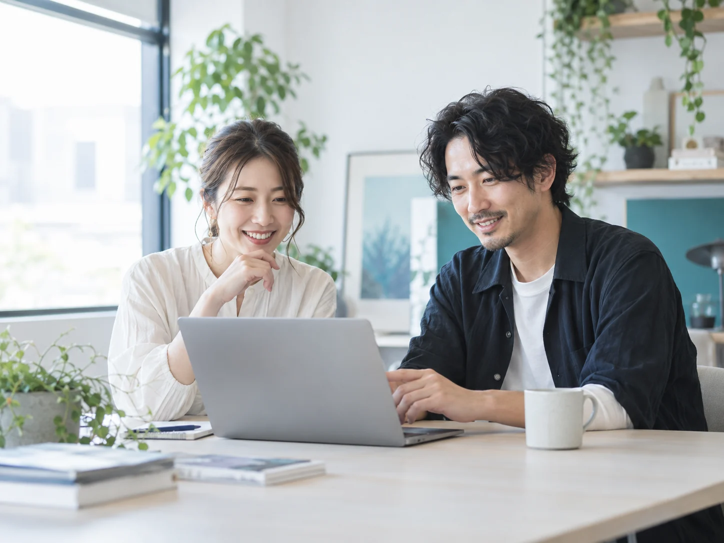 女性と男性のWEBディレクターがノートPCを見ながら打ち合わせるイメージ